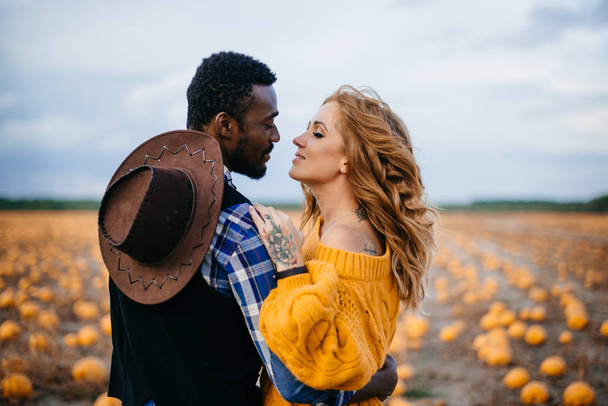 Couple stands in pumpkin field and hugs - Foto, Imagen
