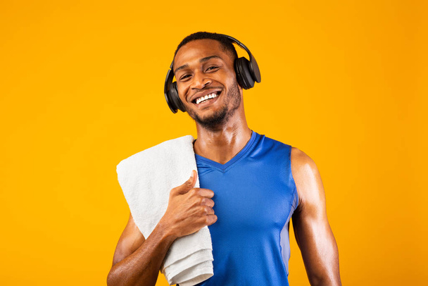 Πορτρέτο του όμορφου μαύρου άνδρα με ακουστικά και πετσέτα - Φωτογραφία, εικόνα
