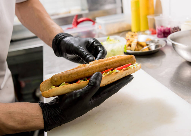 The chef cooking hot dog on a grill. Restaurant. - Фото, зображення