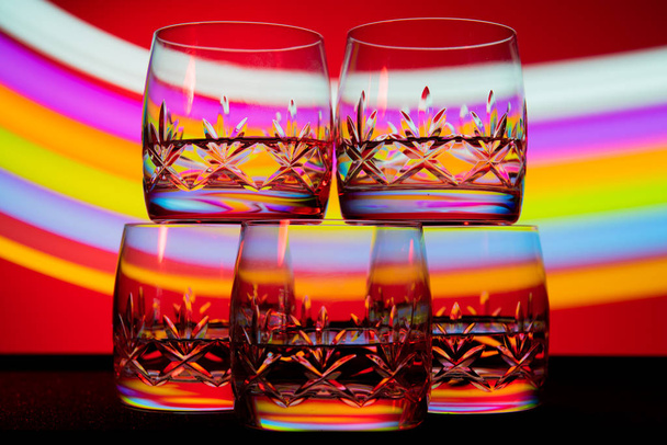 glasses in the multicolored light of the club. - Фото, изображение