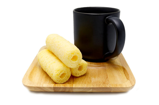 Φρένο καφέ από γλυκά τραγανά ραβδιά καλαμποκιού, σνακ στο ξύλινο πιατάκι με μαύρο καφέ, απομονωμένο σε λευκό φόντο. - Φωτογραφία, εικόνα