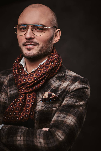 Uomo d'affari elegante di successo in posa in uno studio indossando giacca a scacchi, occhiali e sciarpa
 - Foto, immagini