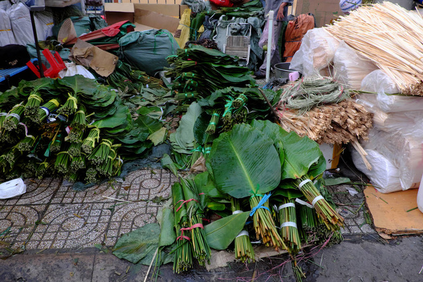 Mercado de folhas tradicional perto de Tet, folhas, corda de bambu, molde de bolo
 - Foto, Imagem