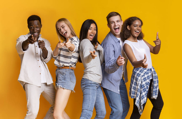 Groupe d'étudiants multiracial joyeux indiquant à la caméra
 - Photo, image