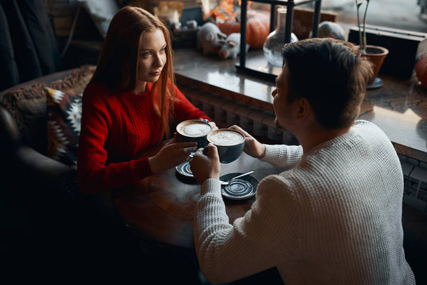 mężczyzna i kobieta w stylowych swetrach czerpią przyjemność z picia cappuccino - Zdjęcie, obraz