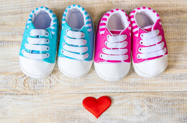 Μπότες μωρού και καρδιά σε ένα ελαφρύ φόντο. Επιλεκτική εστίαση. - Φωτογραφία, εικόνα