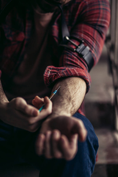 closeup of man injecting drugs, cocaine or heroine in veins - Fotó, kép