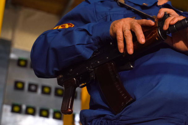 Bir güvenlik görevlisi bir Kalaşnikof 'un elini tutuyor. Silahlı kuvvetler komutanı. - Fotoğraf, Görsel
