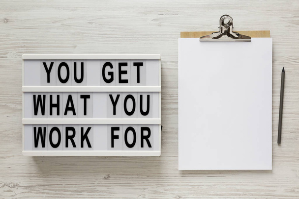 "Du bekommst, wofür du arbeitest" Worte auf einem modernen Brett, Zwischenablage w - Foto, Bild