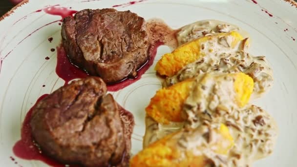 primo piano due pezzi di carne al forno con salsa rossa e guarnire patate ruotare su piatto
 - Filmati, video