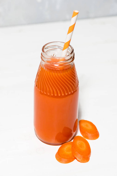 fresh carrot juice in a bottle, vertical top view - Фото, изображение