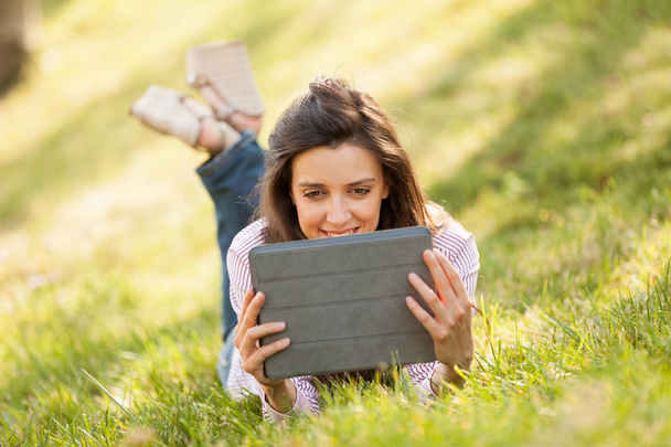 Bella donna bruna con un sorriso stupendo sdraiato su un'erba
 - Foto, immagini