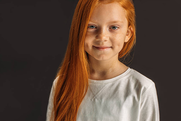 little red haired girl isolated on black - Фото, зображення