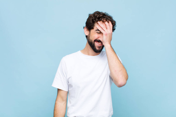 young crazy bearded man looking angry, annoyed and frustrated screaming whats wrong with you against flat wall - Fotoğraf, Görsel
