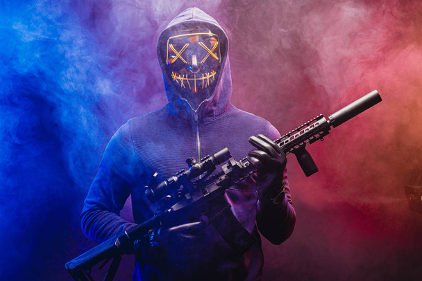 man in mask stand with weapon isolated over smoky space - Foto, immagini
