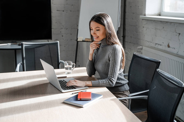 Azjatycka brunetka piękna kobieta w oficjalnym stylu w biurze pracuje sama na laptopie. Pomyślna koncepcja planu biznesowego. Pewny siebie pracownik biurowy w pomieszczeniu współpracowników. Styl życia ludzi - Zdjęcie, obraz