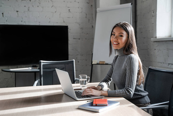 Azjatycka brunetka piękna kobieta w oficjalnym stylu w biurze pracuje sama na laptopie. Pomyślna koncepcja planu biznesowego. Pewny siebie pracownik biurowy w pomieszczeniu współpracowników. Styl życia ludzi - Zdjęcie, obraz