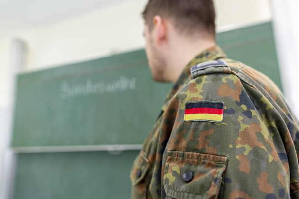 German soldier stands in a classroom . German word Bundeswehr, means german army. - Photo, Image