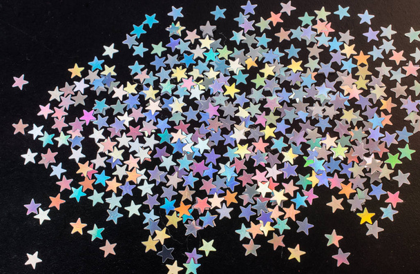 Kleurrijke confetti sterren op donkere achtergrond - Foto, afbeelding