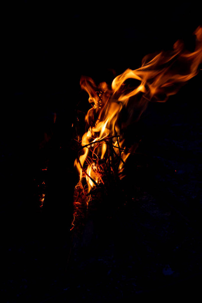 Блестящий горящий огонь в темноте показывает романтическую сторону костра или костра, пожарную безопасность и необходимость страхования от пожара, а также приключения на открытом воздухе с детьми и семьей
 - Фото, изображение