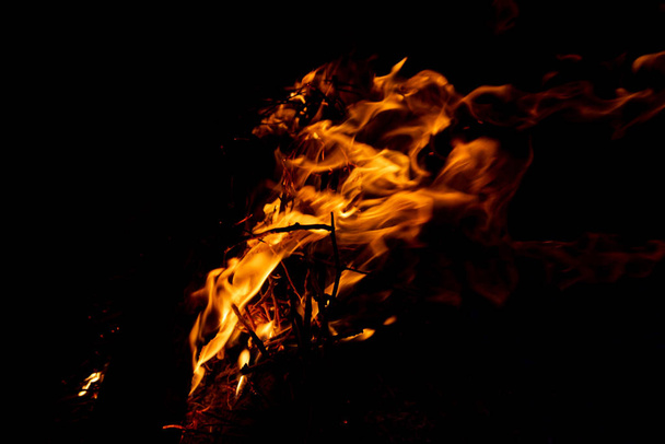 glänzend brennendes Feuer im Dunkeln zeigt die romantische Seite eines Lagerfeuers oder Lagerfeuers, Brandschutz und die Notwendigkeit einer Feuerversicherung sowie Überlebensabenteuer im Freien mit den Kindern und der Familie - Foto, Bild