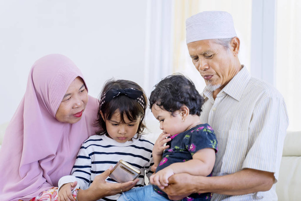 Elderly muslim parents lapping their grandchildren - Φωτογραφία, εικόνα