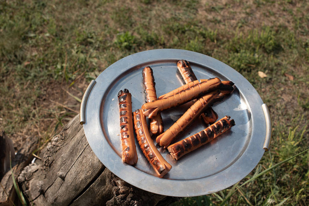 A counter with metal trays containing grilled sausages and meat.Food and cooking - Photo, Image