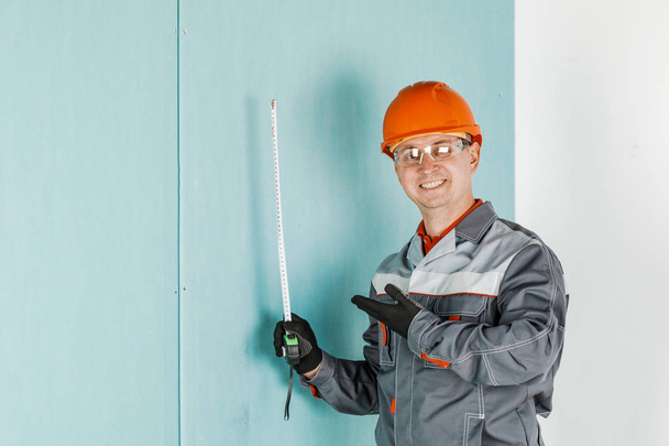 Portret van een mannelijke bouwvakker, beschermd door een gele hij - Foto, afbeelding