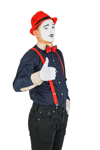 Clown met rode bretels en rode hoed op witte achtergrond - Foto, afbeelding