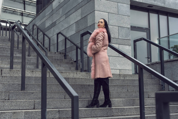 ピンクのコートを着た街のブルネット - 写真・画像