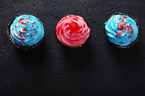 Cupcake cakes pink, blue on a dark background - Fotoğraf, Görsel