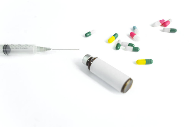 Medizinflasche mit Spritze und Kapseln in weiß - Foto, Bild