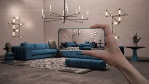 Hand holding smart phone, AR application, simulate furniture and interior design products in real home, architect designer concept, blur background, cosy living room with blue sofa - Photo, Image