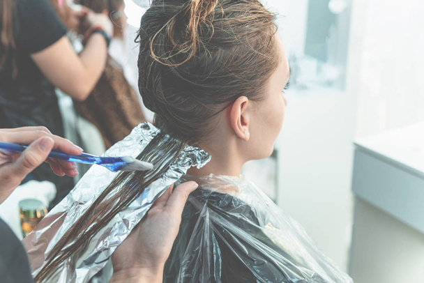 Fryzjer kolorowanki młoda kobieta włosy przy użyciu folii - Zdjęcie, obraz