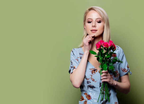Kaunis blondi nainen mekko ruusut vihreällä taustalla
 - Valokuva, kuva