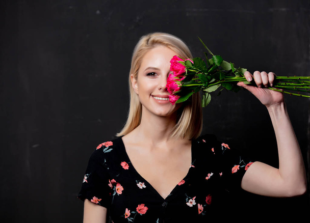 жінка з букетом троянд на темному фоні
 - Фото, зображення