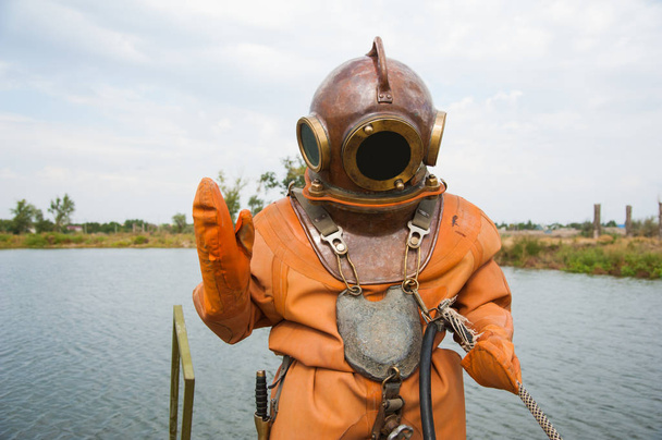 Diver immerses in a vintage deep sea diving suit - Fotoğraf, Görsel