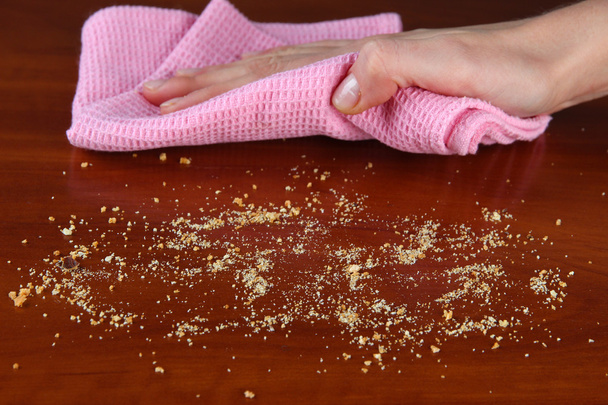 Hand wiping wooden surface with pink rag - Foto, Bild