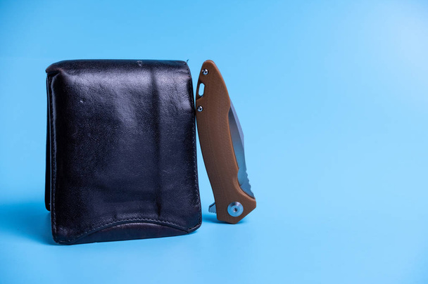 The knife is folded and a purse. Light blue background. - Foto, afbeelding