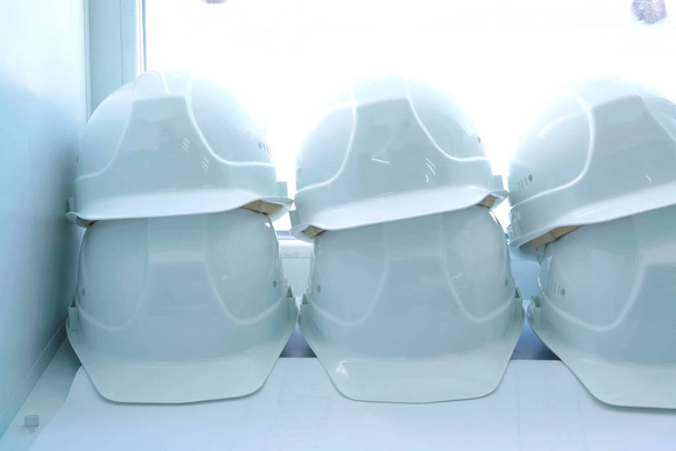 Bílé helmy dělníků leží na parapetu. Ochranné - Fotografie, Obrázek