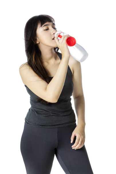 Young woman in sportswear drinking fresh water - Фото, изображение