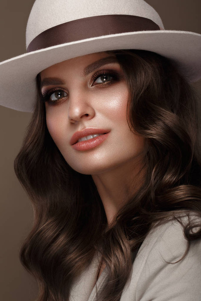 Beautiful sexy woman in a fashionable hat, with classic make-up, wave hair and smile. Beauty face. - Foto, afbeelding