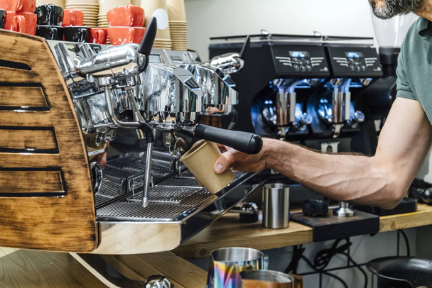 Primer plano de barista sosteniendo el soporte del filtro mientras café mach
 - Foto, imagen