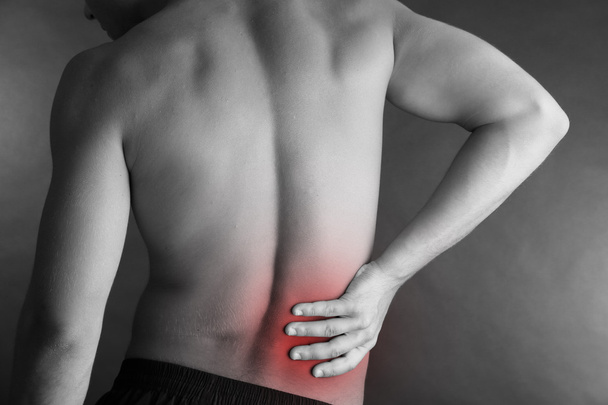 Young man with back pain on grey background - Zdjęcie, obraz