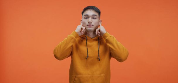 Young man plugging his ears - Valokuva, kuva
