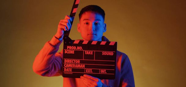 Young man using clapperboard - 写真・画像