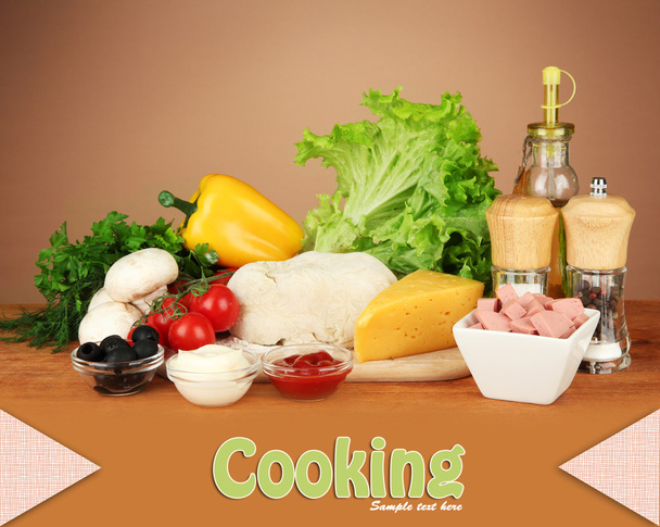 Ingredients for pizza on wooden table on brown background - Foto, Bild