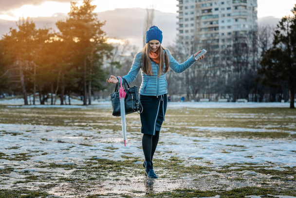 Woman having a city walk in thawing snow - Photo, Image