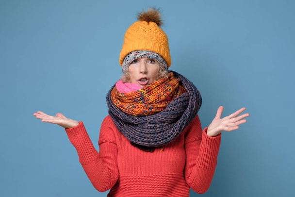 Volwassen vrouw in verschillende hoeden en sjaals fronsen wordt ontstemd en beledigd. - Foto, afbeelding