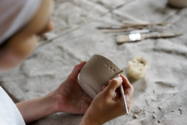 Female hands hold a bowl for casting clay products - Foto, Bild